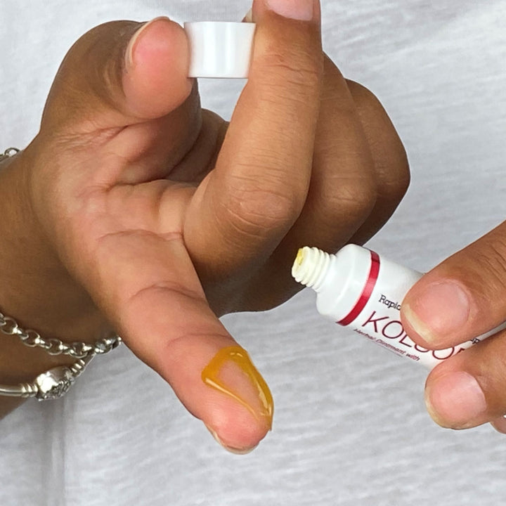 Kolorex Kolsore Lip Ointment placed on finger to show texture